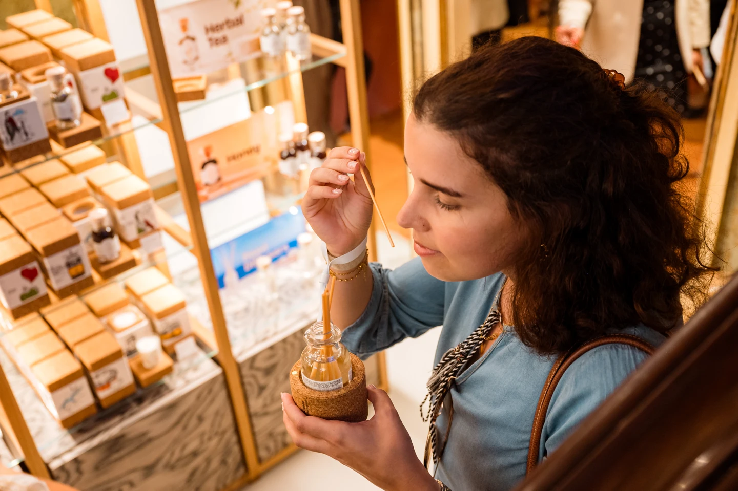 A visitor discovering a fragrance beside the staircase and gift wall