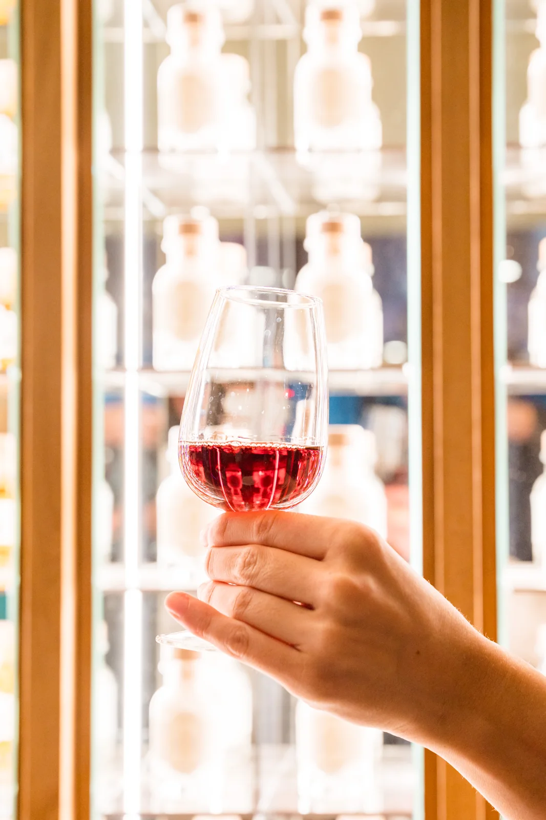 A tasting glass held beside our illuminated gift wall